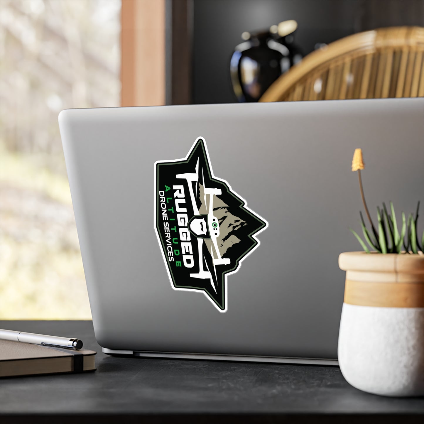 Printify drone service vinyl decals sticker on laptop featuring rugged drone design with mountain background